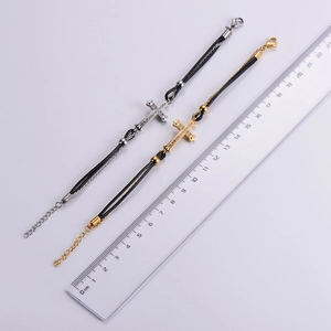 Detail showing gold and silver titanium steel cross bracelets with black cord and lobster clasp