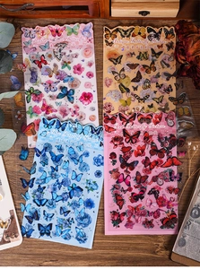 Macro shot of butterfly and flower stickers on vintage wood background for scrapbooking
