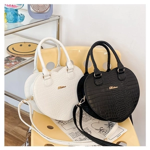 Détail de sacs à main en forme de cœur avec motif crocodile en noir et blanc