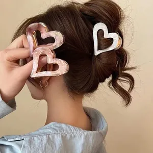 Elegant heart-shaped acetate hair claw clips in marble pink and cream white colors