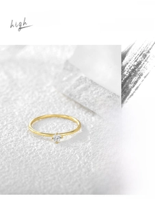 Detail of minimalist 18K gold plated ring featuring a four-prong set round cubic zirconia