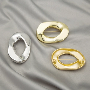 Minimalist irregular geometric round brooches in gold and silver finish on silk background
