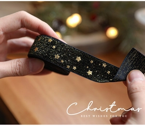 Detail of black velvet ribbon with gold glitter star prints for Christmas gift wrapping