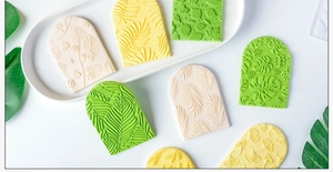 Detailed relief of botanical leaf patterns on fondant cookies and clay molds