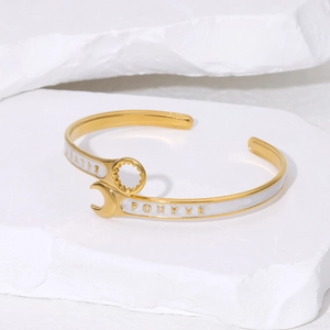 Creative wrench-shaped open bangle in gold finish with white enamel and engraving