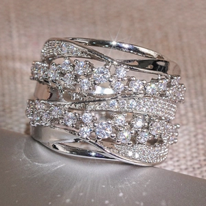 Macro close-up of wide crisscross ring with silver finish and shimmering zircon stones