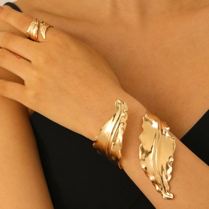Polished golden leaf open bangle and matching ring set showcased on model skin