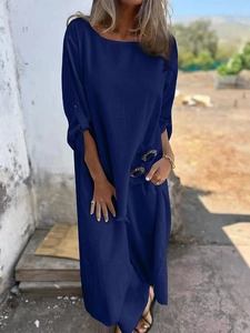 Detail of dark blue loose dress featuring functional pockets and button design