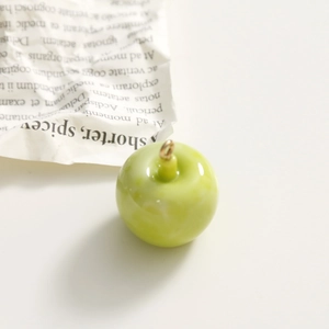 Detail of green apple resin pendant with marble texture and golden metal loop