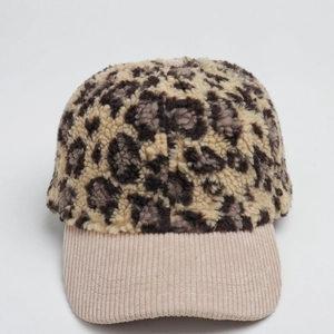 Close-up of leopard faux fur baseball cap with beige corduroy brim and soft texture