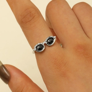 Detail of silver cat-eye glasses ring with black gemstones and white crystals