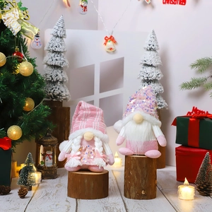 Pink Christmas sequin plush gnome dolls on wooden base with festive warm light decor