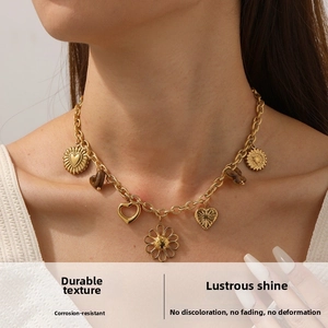 Close-up of gold stainless steel necklace with heart and sunflower charms worn by model