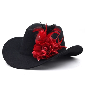 Detail of western wool fedora featuring large red fabric flower and feather accents