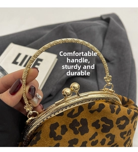 Macro detail of antique gold metal handle with floral relief on leopard print bag