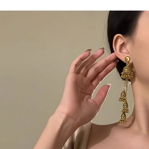 Detail of vintage gold bohemian layered bell earrings worn on model for elegant styling