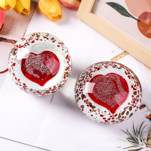 Detailed top view of a heart-shaped crystal glass paperweight with red internal bubbles