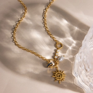 Dettaglio della collana in acciaio inossidabile 18K con pendente sole, perla e zirconi