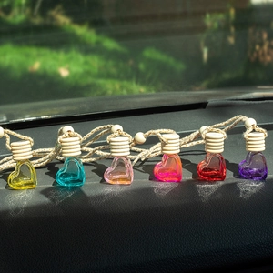 Set of 6 heart-shaped glass car perfume bottles with wooden caps on a dashboard