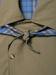 Close-up of the lapel and waist belt tie showing the plaid lining of the jacket