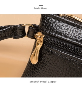 Close-up of smooth gold metal zipper and black litchi grain leather texture on mini wallet