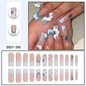 Long nude French press-on nails with white flowers and blue crystal rhinestones