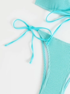 Detail of ribbed turquoise bikini bottom with adjustable side tie and bow design