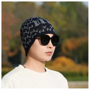 Close-up of navy blue knit beanie with gray jacquard patterns on model outdoors