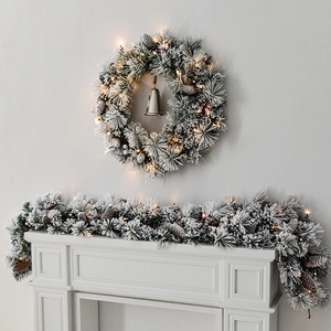 Frosted Christmas wreath and garland with LED lights, pine cones, berries and bells