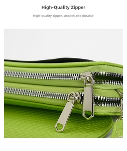 Close-up of neon green crossbody bag featuring dual zippers and heart-shaped metal pulls