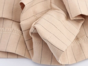 Détail macro du tissu à fines rayures kaki et de l'armure sergée sur l'ensemble