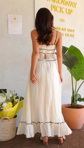 Detail of the open back ruffle top and tiered maxi skirt set in cream pleated fabric
