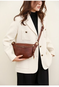 Detail der braunen Leder-Satteltasche mit Vintage-Bronzeschnallen und Reißverschluss