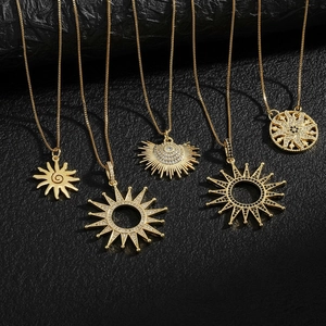 Punk style golden sun necklaces with sparkling zircon inlays on black leather background