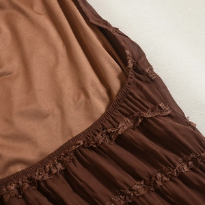 Detailed macro view of brown tiered fabric with lace trim and ruched elastic stitching