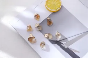 Macro detail of natural raw citrine birthstone pendants with gold plated irregular edges