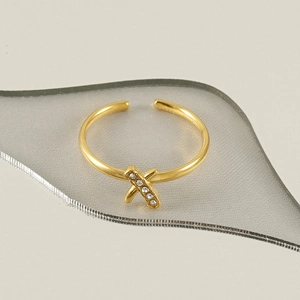Macro shot of gold 18k stainless steel X-shaped ring with pavé sparkling crystals