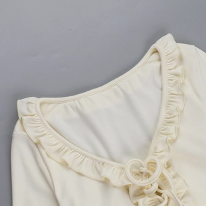 Détail du col en V à volants avec cordon de serrage en forme de cœur sur haut beige