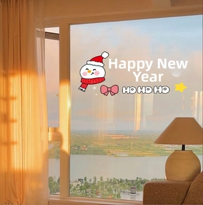 Close-up of pink bow and snowman static window stickers in warm sunset lighting
