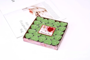 Close-up of 50 green heart-shaped smokeless tealight candles in romantic gift packaging
