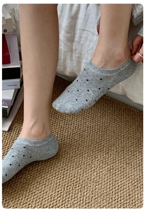 Detailed close-up of grey polka dot no-show socks with ribbed ankle design for women