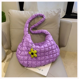 Detailed texture of purple quilted puffy cloud bag with fluorescent yellow floral charm