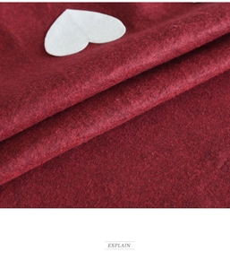 Detail view of deep red felt fabric texture with white heart decoration for Christmas tree skirt