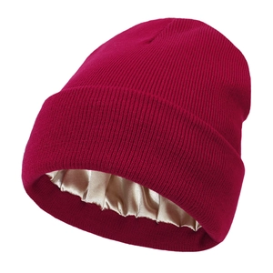 Detail of burgundy knitted beanie showing the smooth champagne satin lining for hair care
