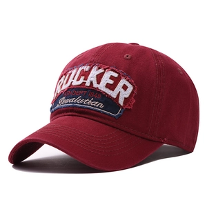 Détail d'une casquette en coton bordeaux avec écusson brodé vintage RUCKER style