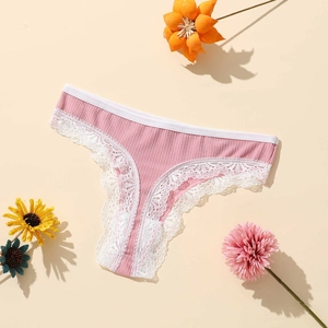 Gros plan sur un string en polyester rose respirant avec dentelle blanche et texture côtelée