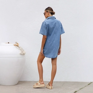 Outdoor shot of a women's short-sleeve denim shirt dress with a lapel and loose fit