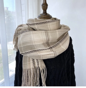 Close-up of thick beige and brown checkered scarf with long fringe tassels