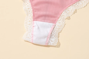 Gros plan sur le tissu côtelé rose et la dentelle florale blanche d'un string femme