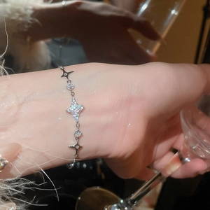Detailaufnahme der funkelnden Sternanhänger an einem Silberarmband mit Zirkon-Besatz